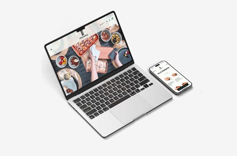 Ein Laptop und ein Smartphone zeigen eine Website für Essenslieferungen mit Barrierefreiheit-Funktionen an; der Laptop zeigt eine Draufsicht auf die Gerichte, während das Telefon Menüpunkte und Preise auflistet. Beide Geräte befinden sich vor einem weißen Hintergrund.