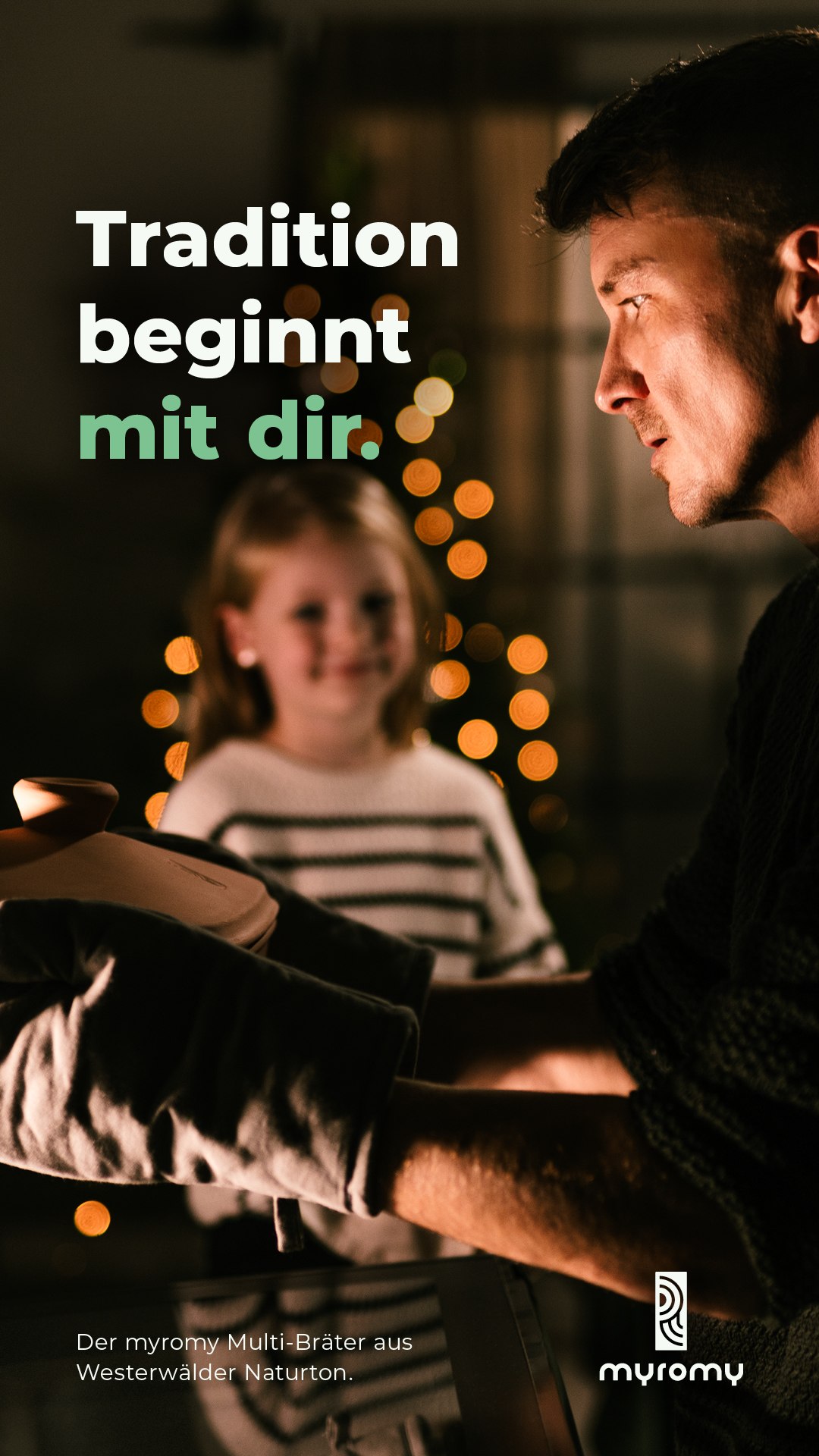 Ein Mann serviert Essen, während ein lächelndes junges Mädchen in einem warm beleuchteten Raum mit verschwommenen Weihnachtslichtern zusieht - perfekt für die Event-Kampagne Tag der deutschen Einheit. Tradition beginnt mit dir. Der myromy Multi-Bräter aus Westerwälder Naturton.