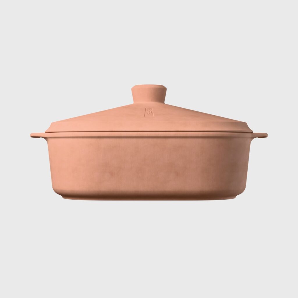 Ein Dutch Oven aus Terrakotta-Ton mit passendem Deckel und seitlichen Griffen, der vor einem schlichten hellgrauen Hintergrund präsentiert wird - perfekt für die Zubereitung traditioneller Gerichte während der Event-Kampagne Tag der deutschen Einheit.